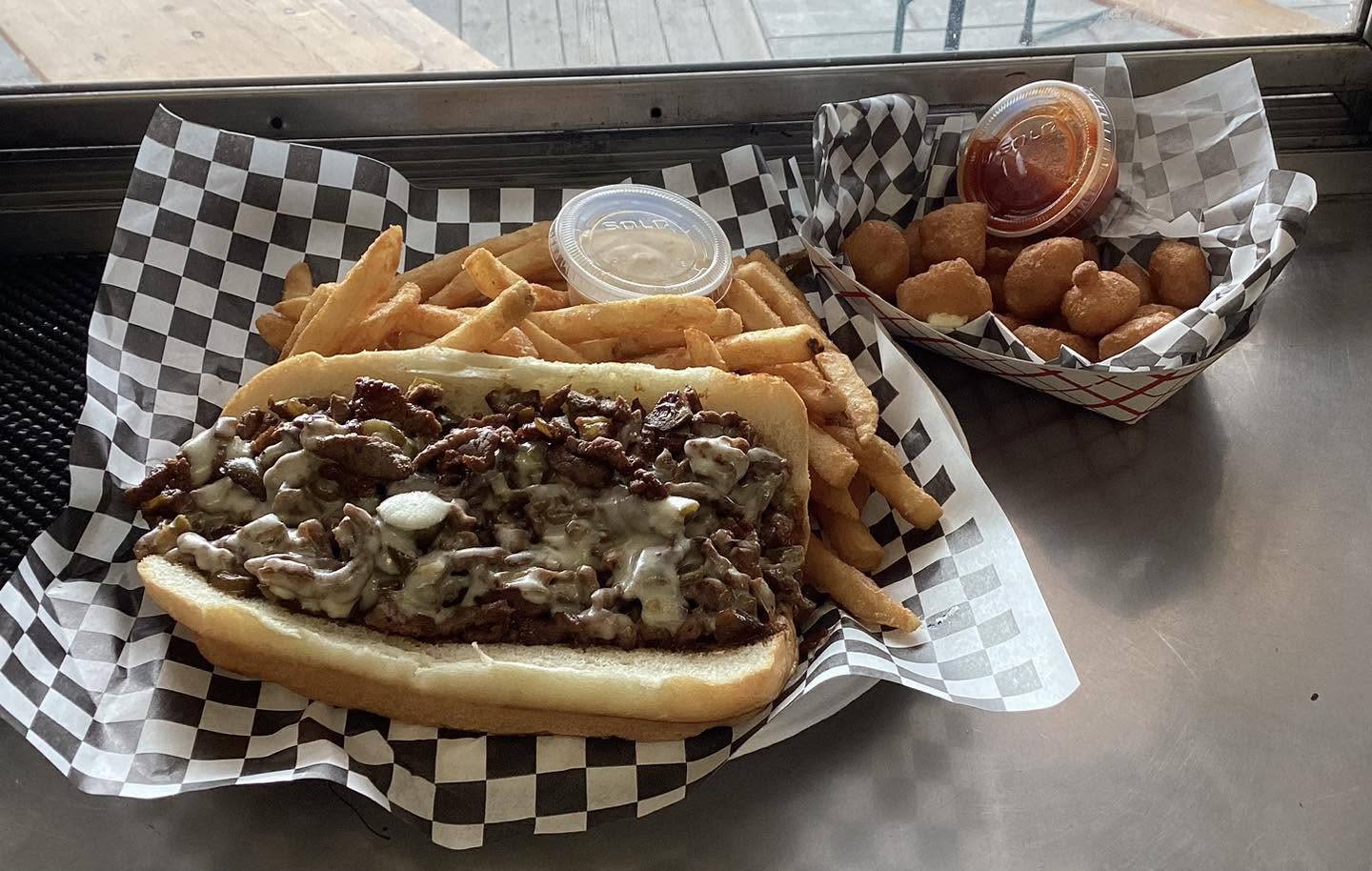 Cheesesteak with fries and a side of beer battered cheese curds