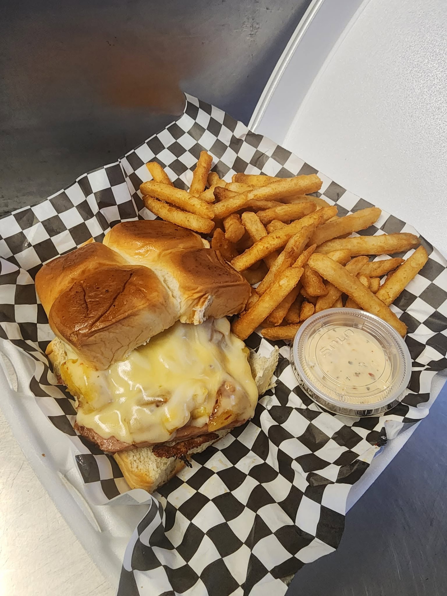 Cheesy sandwich on sweet rolls served with crispy fries and dipping sauce